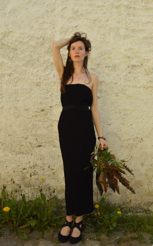 Model is wearing black midi strapless dress