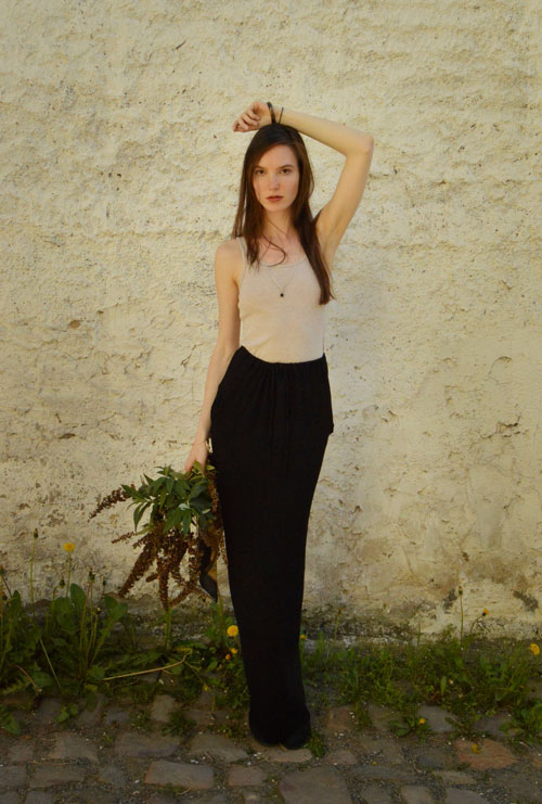 Model is wearing reversible long black skirt