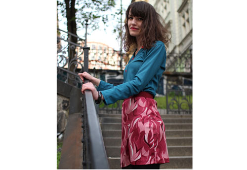 Girl is wearing blue pullover and recycled short pink skirt with psychadelic art pattern from the 60´s