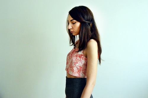 Girl is wearing short sleeveless top with red and white flowers recycled from an old dress