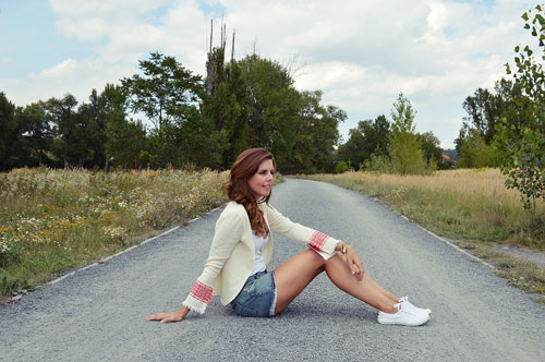 Woman is wearing white cardigan with red and white folk sleeves