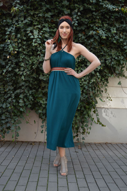 Model is wearing reversible emerald midi dress tied behind neck