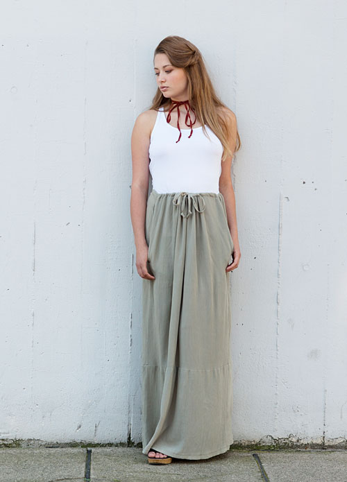 Model is wearing reversible long pale green skirt with pockets