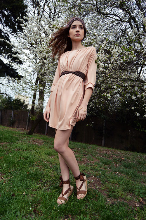 Model is wearing short reversible salmon pink dress with two sleeves