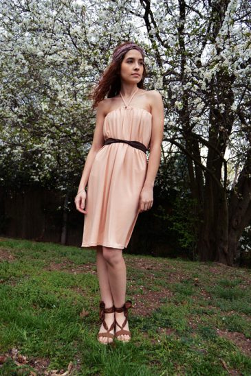 Short pink variable dress tied behind neck Model is wearing reversible salmon pink short dress tied behind neck